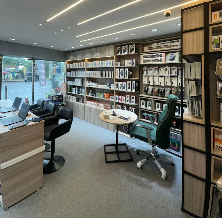 Modern office interior with bookshelves, desk, and chairs.